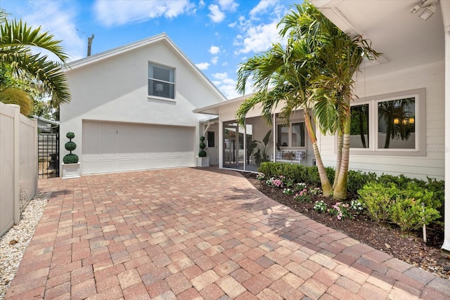 1841 Datura St, Sarasota, FL 34239 - view of front of home featuring decorative driveway, fence, a garage, and stucco siding