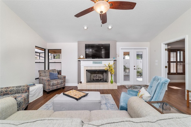 living area with vaulted ceiling, plenty of natural light, a ceiling fan, french doors, and a textured ceiling