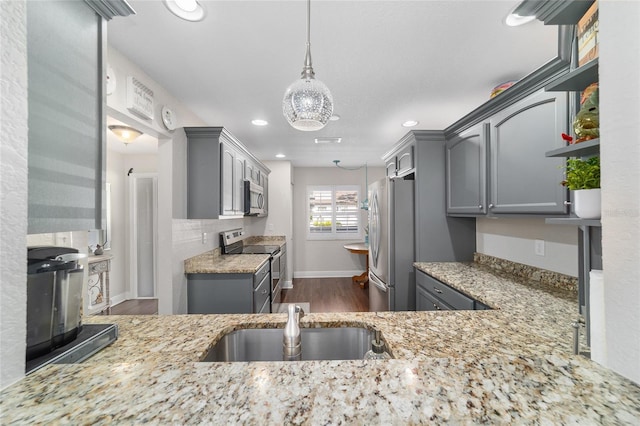 kitchen with stainless steel appliances, gray cabinets, dark wood-style flooring, a sink, and recessed lighting
