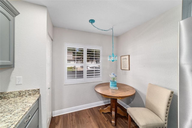 dining room with dark wood finished floors and baseboards