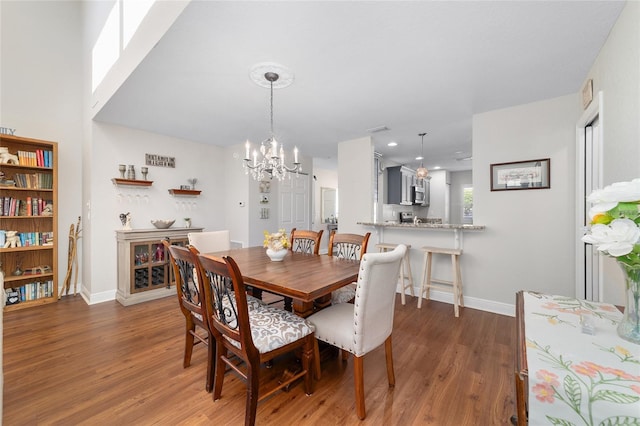 dining room featuring a chandelier, light wood finished floors, and baseboards
