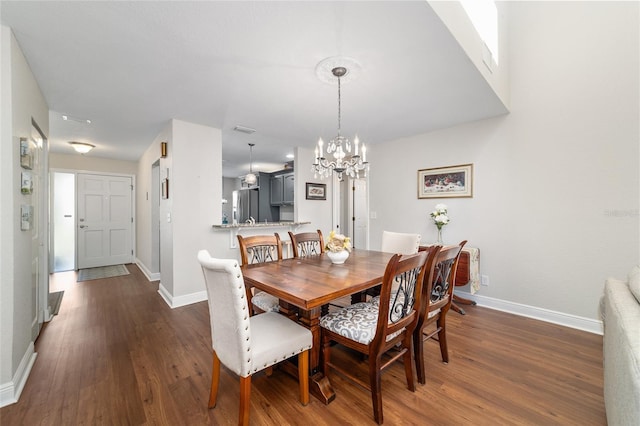 dining space featuring dark wood-style floors, a chandelier, and baseboards