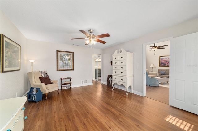 living area with ceiling fan, wood finished floors, and baseboards