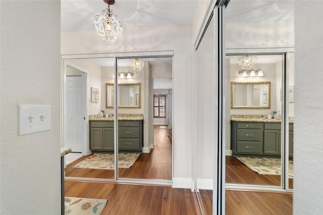full bath featuring a chandelier, wood finished floors, and vanity
