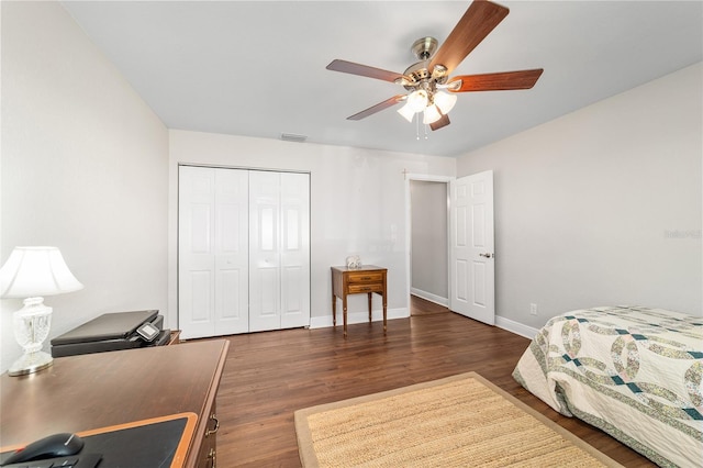 bedroom featuring wood finished floors, an office area, baseboards, a closet, and ceiling fan