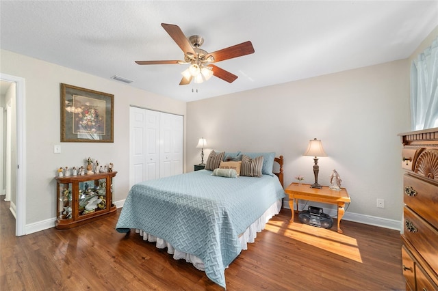 bedroom featuring baseboards, wood finished floors, a closet, and ceiling fan