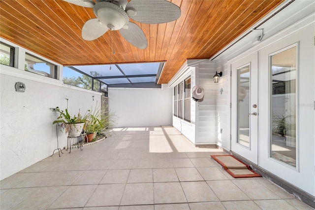 view of patio with ceiling fan and glass enclosure