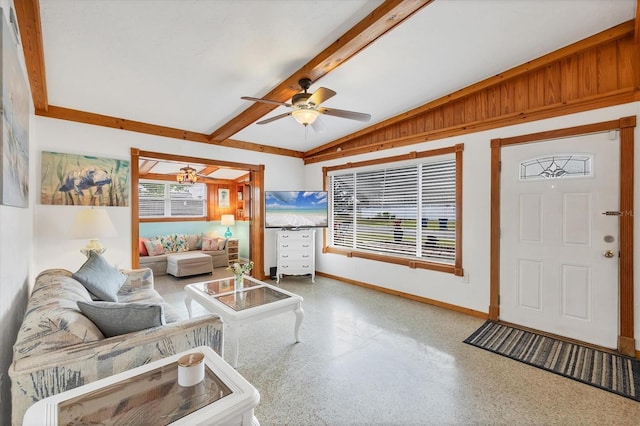living area with speckled floor, baseboards, and a ceiling fan