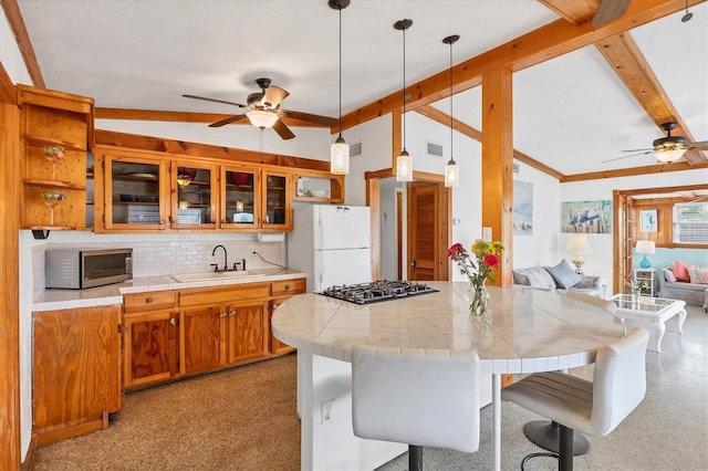 kitchen featuring stainless steel microwave, a ceiling fan, a sink, and freestanding refrigerator