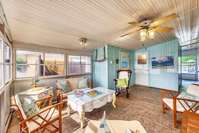 sunroom / solarium with ceiling fan, lofted ceiling, wooden ceiling, and wood walls
