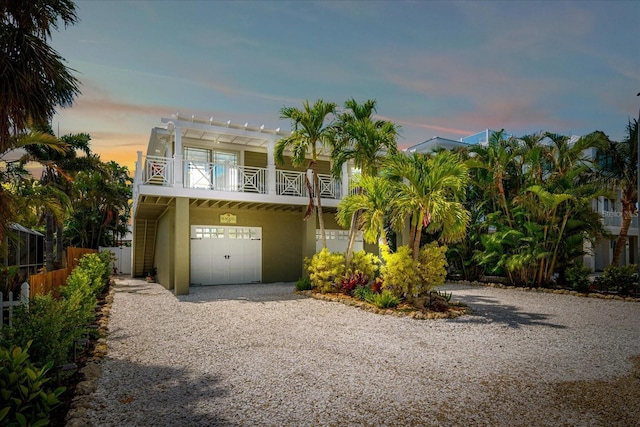 229 S Harbor Dr, Holmes Beach, FL 34217 - coastal inspired home with an attached garage, driveway, stucco siding, and a pergola
