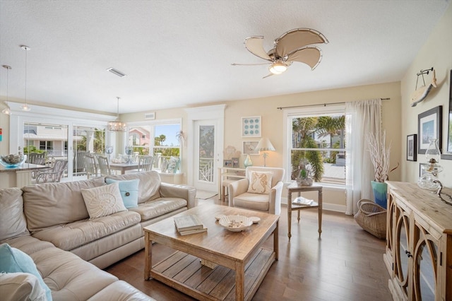 229 S Harbor Dr, Holmes Beach, FL 34217 - living area with plenty of natural light, wood finished floors, a ceiling fan, and a textured ceiling