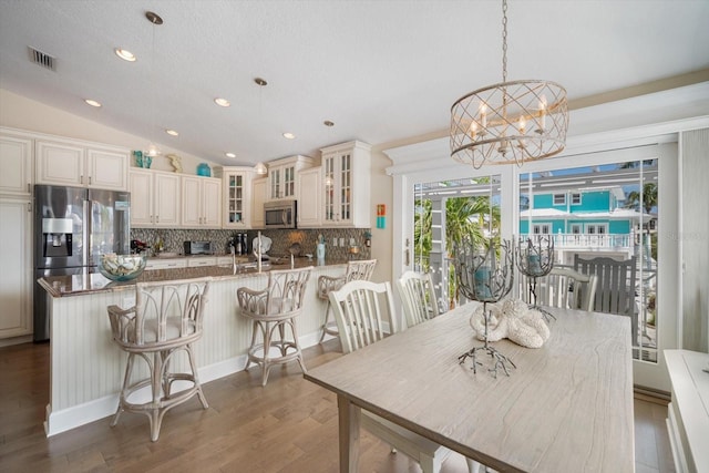 229 S Harbor Dr, Holmes Beach, FL 34217 - dining space with a chandelier, wood finished floors, recessed lighting, and vaulted ceiling