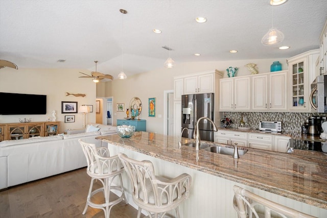 229 S Harbor Dr, Holmes Beach, FL 34217 - kitchen featuring a sink, appliances with stainless steel finishes, open floor plan, light stone countertops, and vaulted ceiling