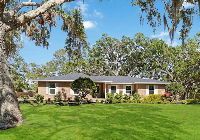 ranch-style house featuring brick siding and a front yard