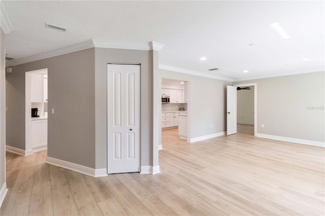 unfurnished living room with ornamental molding, light wood-style flooring, baseboards, and recessed lighting