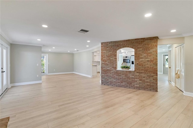 spare room featuring ornamental molding, light wood-style flooring, recessed lighting, and baseboards