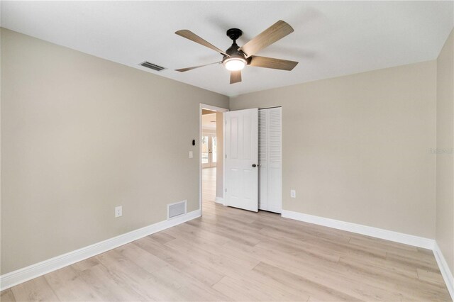 unfurnished bedroom featuring light wood finished floors, baseboards, a closet, and ceiling fan
