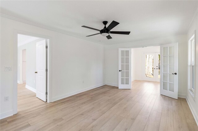 unfurnished room with french doors, light wood-type flooring, a ceiling fan, baseboards, and ornamental molding