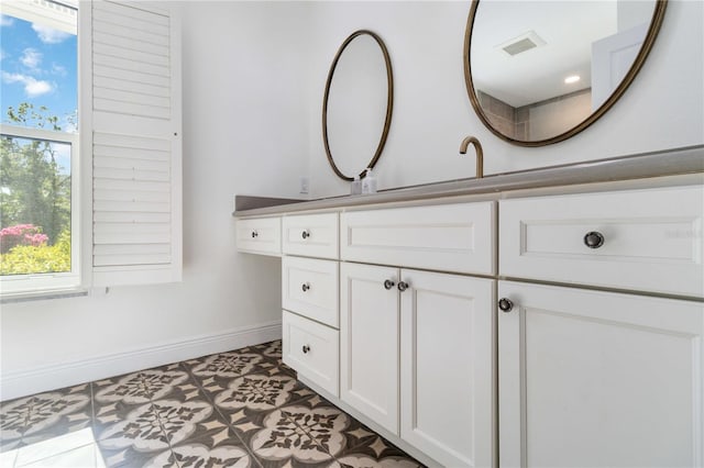 bathroom featuring baseboards, vanity, and healthy amount of natural light