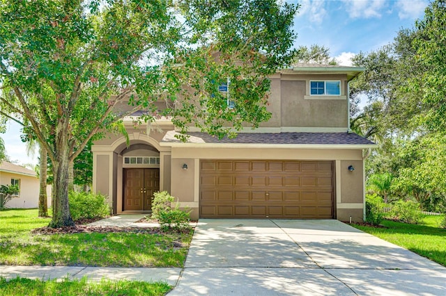 view of front of property with stucco siding, driveway, and an attached garage