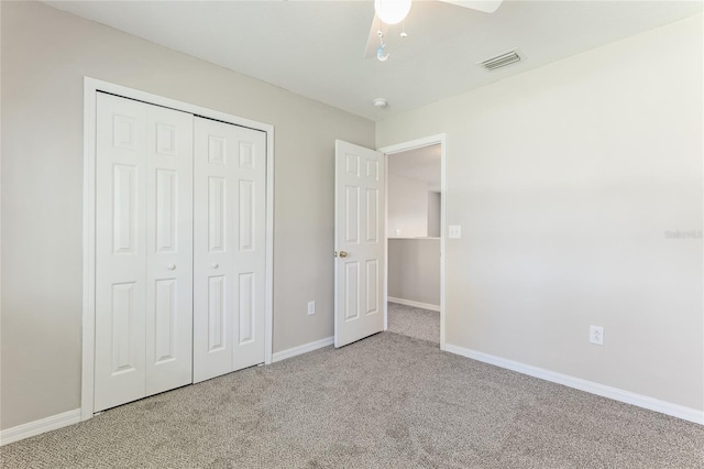 unfurnished bedroom featuring carpet, baseboards, a closet, and ceiling fan