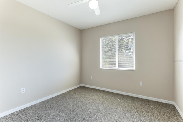 empty room featuring carpet floors, a ceiling fan, and baseboards