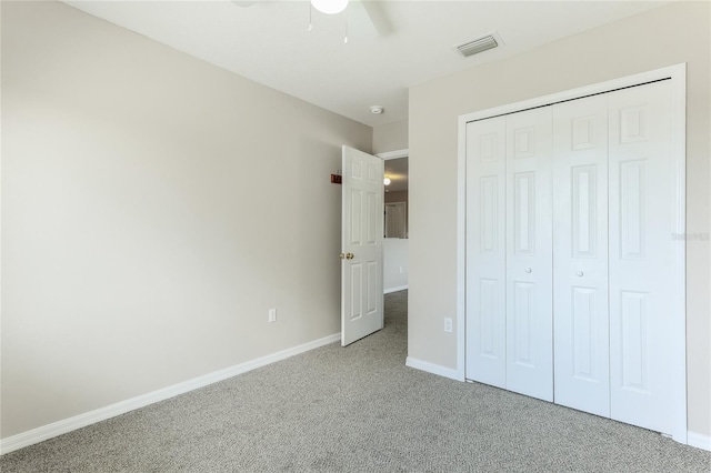 unfurnished bedroom with carpet floors, a closet, baseboards, and a ceiling fan