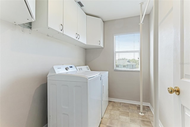 laundry area featuring cabinet space, washer and clothes dryer, baseboards, and stone finish flooring