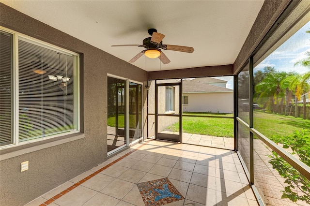 unfurnished sunroom with ceiling fan
