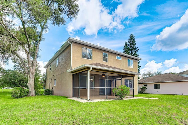 back of house with a sunroom, a lawn, a ceiling fan, and stucco siding
