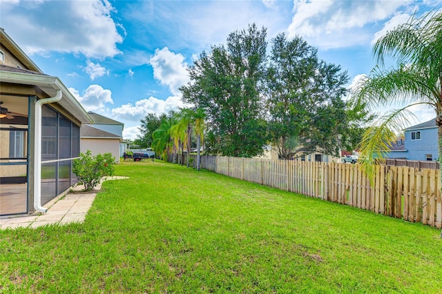 view of yard with a sunroom and ceiling fan