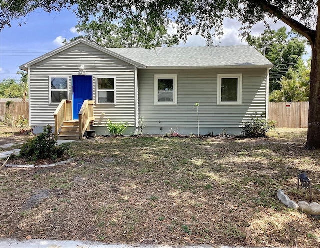 view of front of property featuring fence and roof with shingles