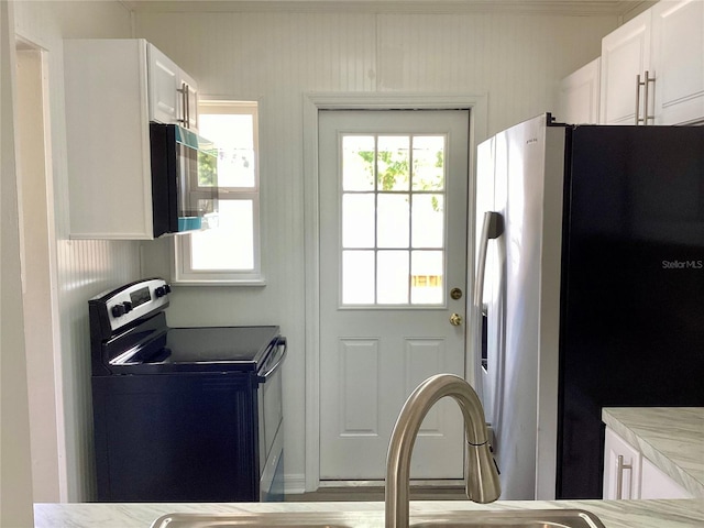 kitchen with appliances with stainless steel finishes, white cabinetry, and light countertops