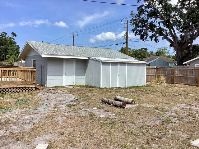 view of outdoor structure with fence and an outbuilding