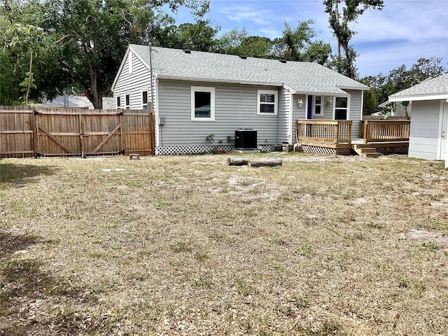 rear view of house with a wooden deck, central AC unit, fence, and a gate