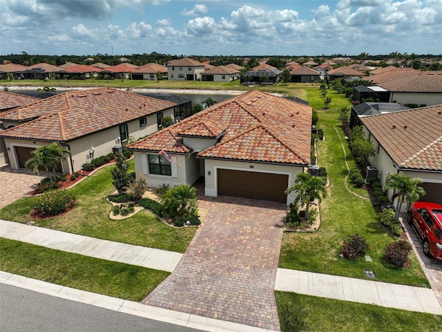 20542 Trattoria Loop, Venice, FL 34293 - mediterranean / spanish-style home featuring a garage, a residential view, decorative driveway, stucco siding, and a tiled roof