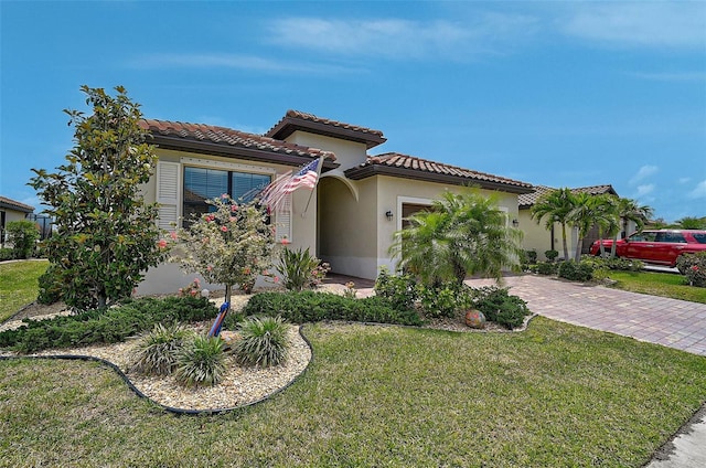 20542 Trattoria Loop, Venice, FL 34293 - mediterranean / spanish house with an attached garage, decorative driveway, a front lawn, stucco siding, and a tile roof