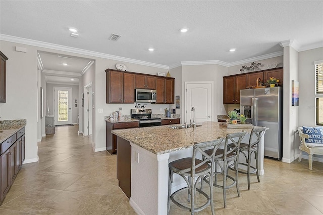 20542 Trattoria Loop, Venice, FL 34293 - kitchen with stainless steel appliances, a sink, light stone countertops, a center island with sink, and a kitchen breakfast bar