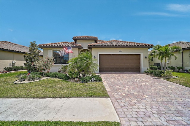 20542 Trattoria Loop, Venice, FL 34293 - mediterranean / spanish home featuring decorative driveway, stucco siding, an attached garage, a tile roof, and a front lawn