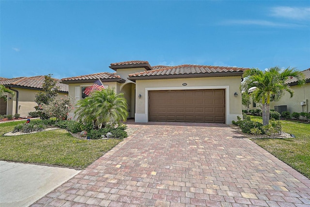 20542 Trattoria Loop, Venice, FL 34293 - mediterranean / spanish-style home with decorative driveway, stucco siding, an attached garage, and central AC unit