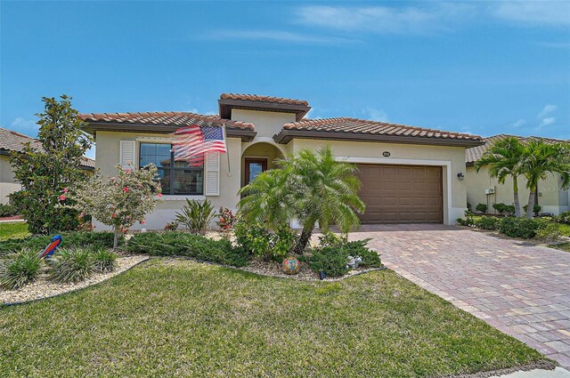 20542 Trattoria Loop, Venice, FL 34293 - mediterranean / spanish house with stucco siding, an attached garage, decorative driveway, a tile roof, and a front yard