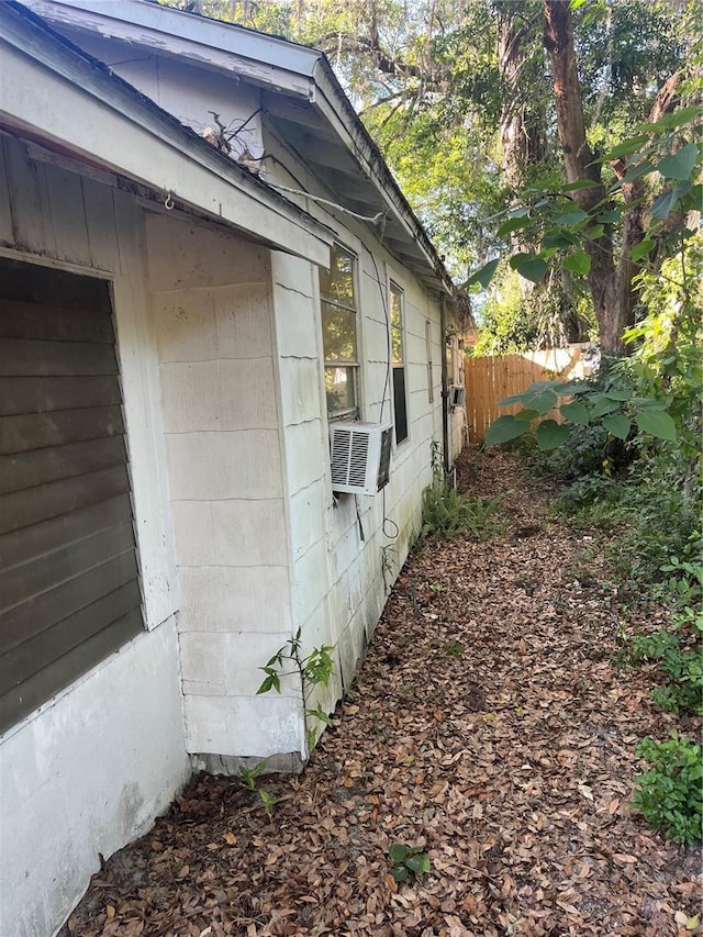 view of side of property with fence and cooling unit