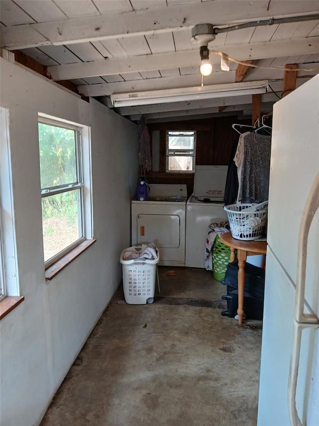 below grade area with washing machine and dryer and freestanding refrigerator