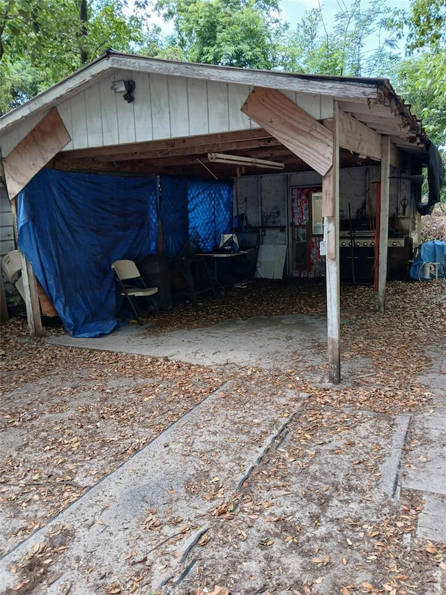 view of outdoor structure featuring concrete driveway and a carport