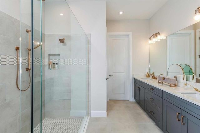 bathroom with tiled shower, tile patterned floors, and double vanity