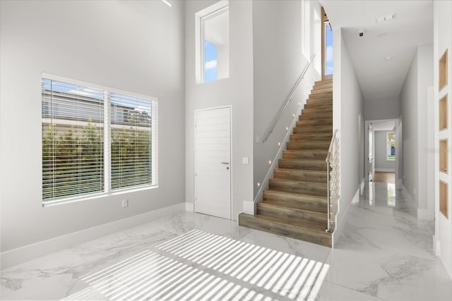 1521 Chestnut Ave, Winter Park, FL 32789 - stairs with marble tiled flooring, a high ceiling, and baseboards