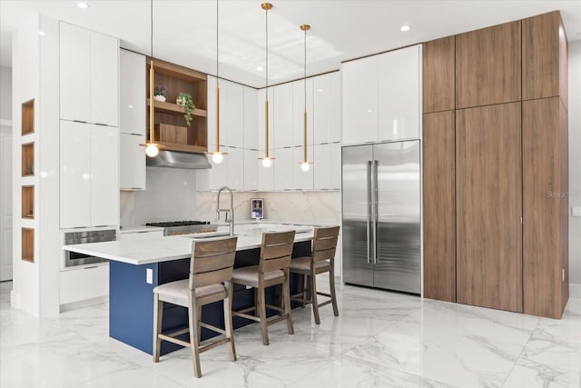 1521 Chestnut Ave, Winter Park, FL 32789 - kitchen featuring appliances with stainless steel finishes, modern cabinets, under cabinet range hood, white cabinetry, and a kitchen island with sink