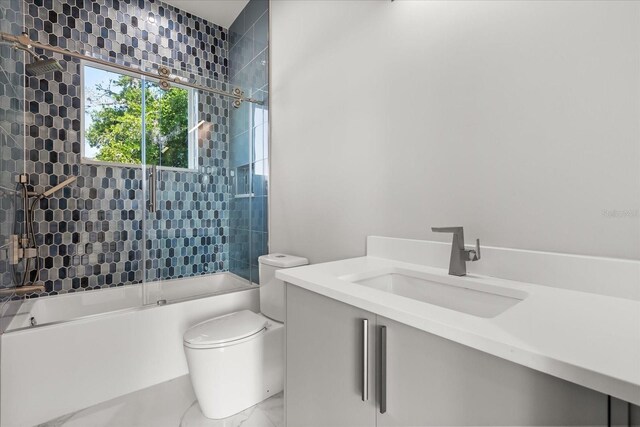 1521 Chestnut Ave, Winter Park, FL 32789 - full bathroom with enclosed tub / shower combo, vanity, toilet, and marble look tile flooring