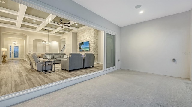 living room featuring arched walkways, beamed ceiling, recessed lighting, coffered ceiling, and a ceiling fan
